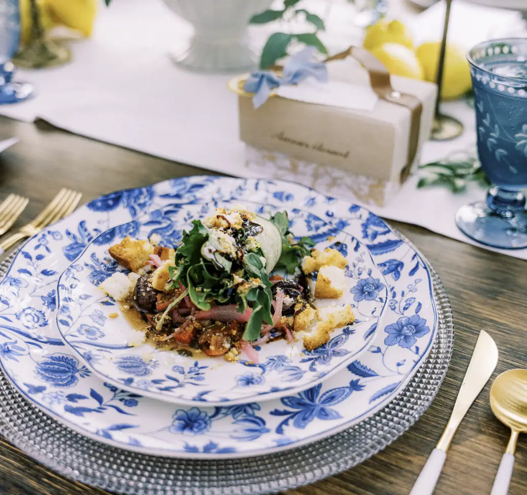 A plated salad on blue and white china at a Tastefully Yours wedding